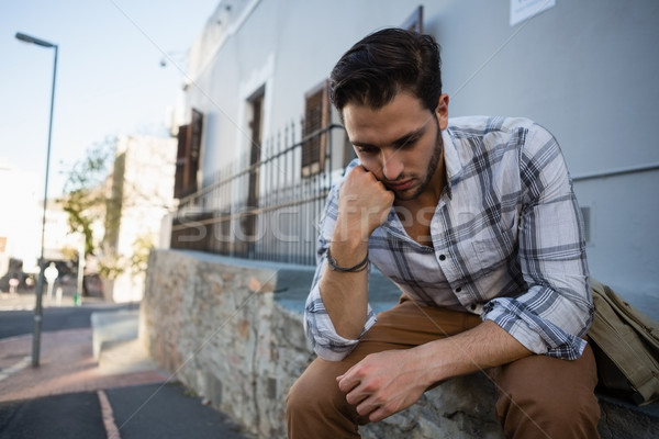 Homme regardant vers le bas séance mur jeune homme ordinateur [[stock_photo]] © wavebreak_media