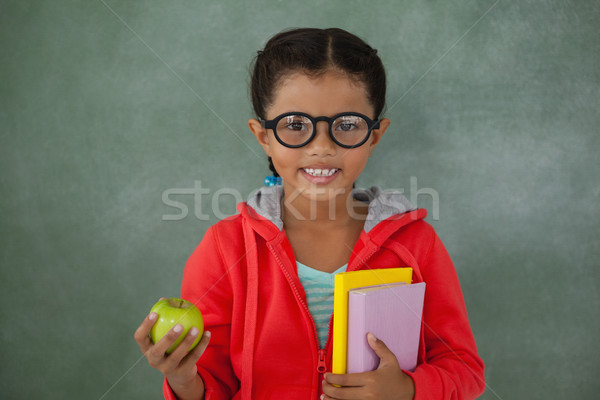 Young girl in glasses holding apple and books Stock photo © wavebreak_media
