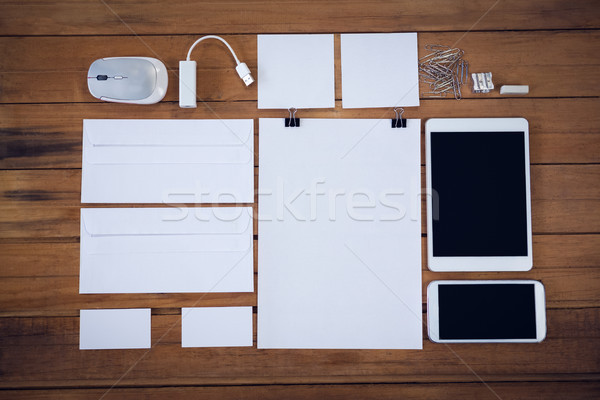 Overhead view of envelopes with technologies and office supply on wooden table Stock photo © wavebreak_media