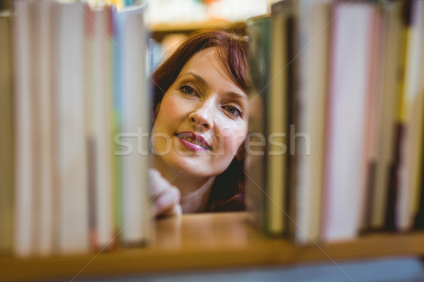 Mature student picking out book in library Stock photo © wavebreak_media