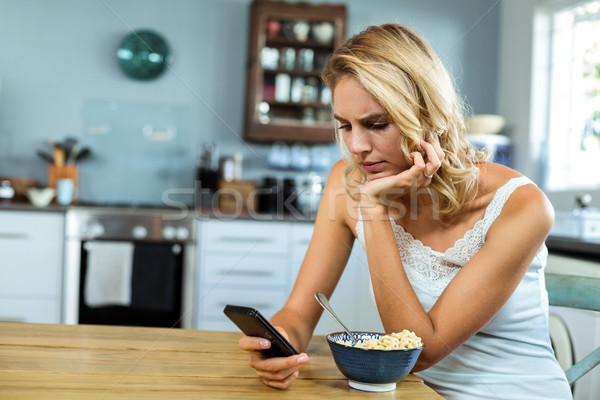 Woman using mobile phone at home Stock photo © wavebreak_media