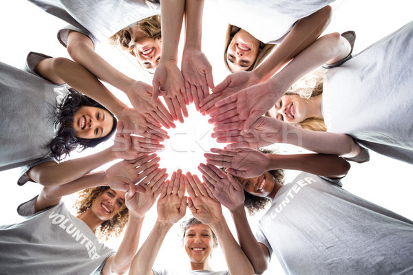 Happy volunteers standing in a circle with their hands together Stock photo © wavebreak_media