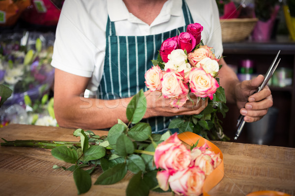 Male florist holding bunch of roses and shears Stock photo © wavebreak_media