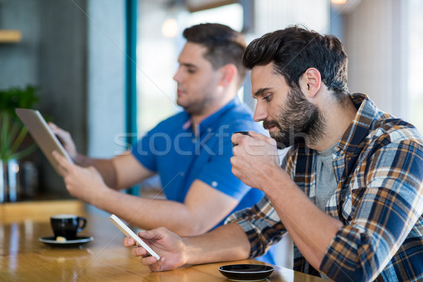 Hombres teléfono móvil digital tableta taza café Foto stock © wavebreak_media