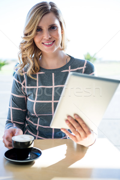 Woman using digital tablet while having cup of coffee Stock photo © wavebreak_media