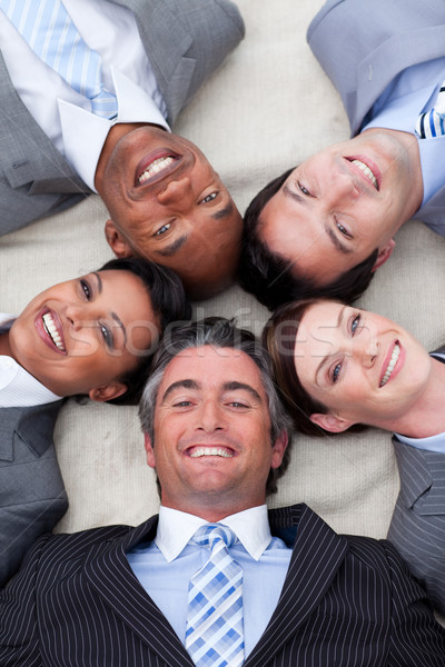 Smiling business team lying on the floor with heads together Stock photo © wavebreak_media