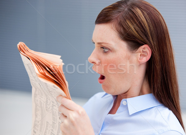 Stock photo: Astonished businesswoman reading newspaper