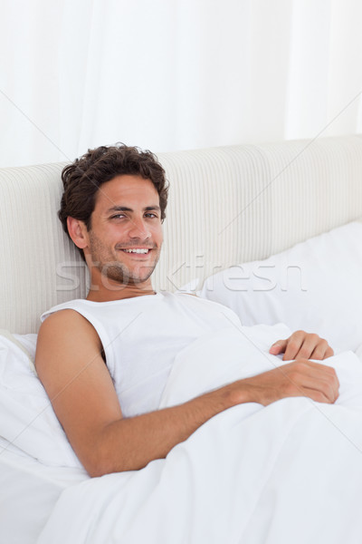 Handsome man lying down in his bed at home Stock photo © wavebreak_media