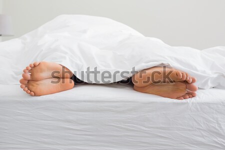 Two pair of feet far from each other in a bed Stock photo © wavebreak_media