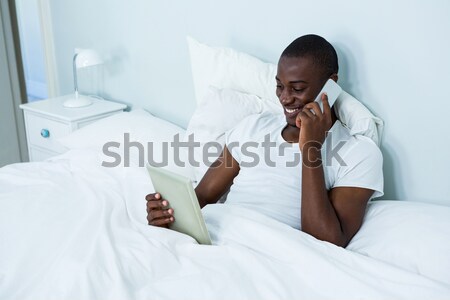 Woman stretching her arms while waking up in her bedroom Stock photo © wavebreak_media