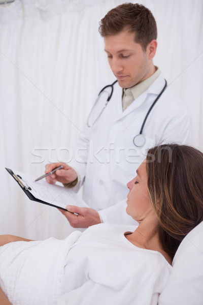 Stock photo: Doctor explaining his bedridden patient the examination results