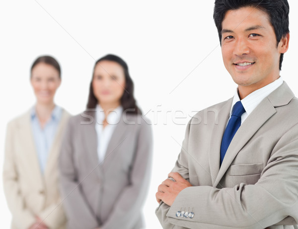 Stock photo: Smiling young businessman with colleagues behind him against a white background