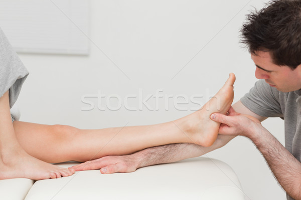 Physiotherapist looking at the foot of a patient in a room Stock photo © wavebreak_media