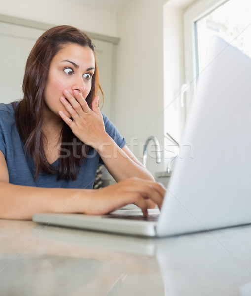 Femme regarder étonné utilisant un ordinateur portable cuisine ordinateur [[stock_photo]] © wavebreak_media