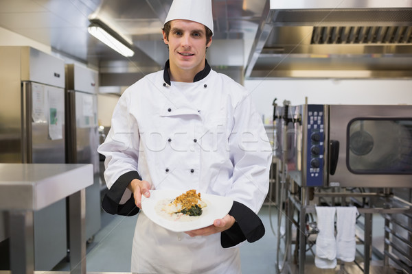 Cheerful chef presenting his plate in the kitchen Stock photo © wavebreak_media