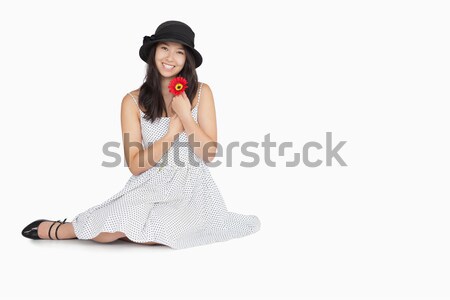 Woman with flower wearing a polka dot dress sitting on floor Stock photo © wavebreak_media