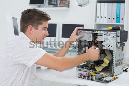 Technician fixing wires of server while holding clipboard Stock photo © wavebreak_media