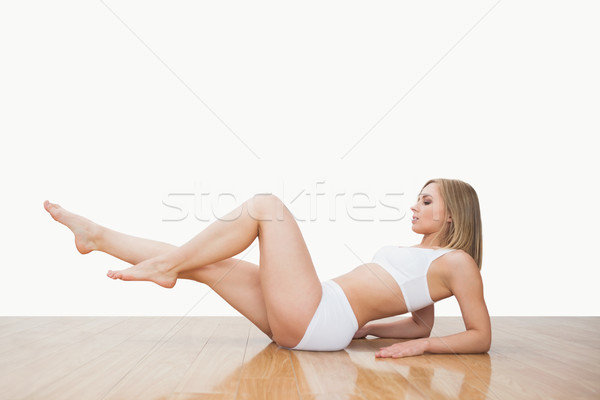 Stock photo: Side view of young  woman in yoga pose on hardwood floor