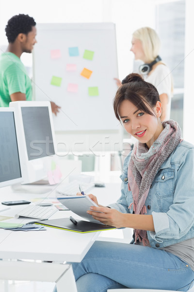 Stock photo: Artist drawing something on graphic tablet with colleagues behin