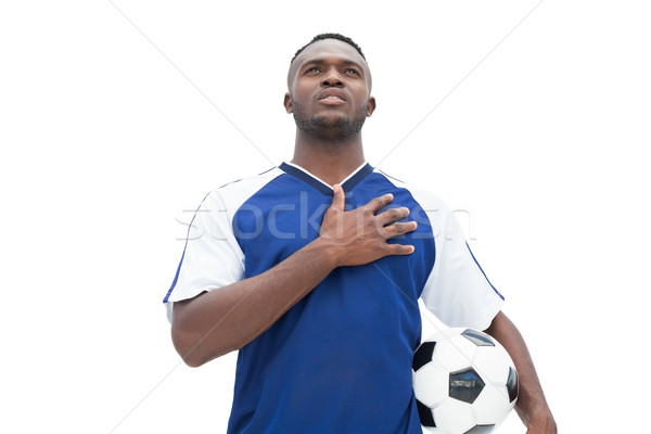 Football player in blue standing with the ball listening to anth Stock photo © wavebreak_media