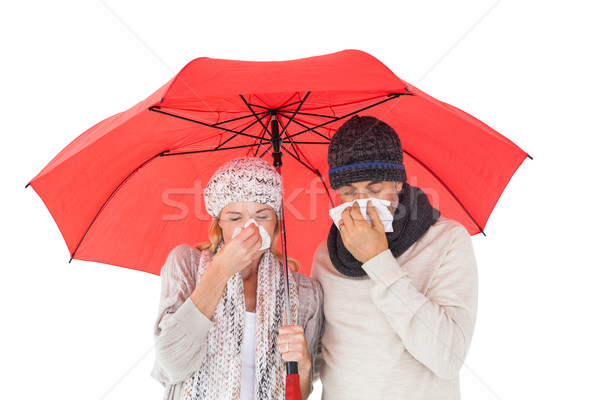 Couple in winter fashion sneezing under umbrella Stock photo © wavebreak_media