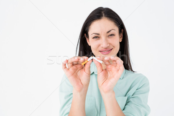 Smiling woman snapping cigarette in half Stock photo © wavebreak_media