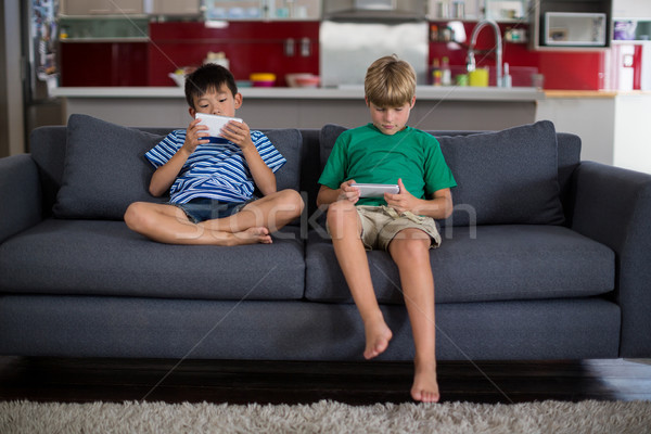 Siblings using mobile phone in living room Stock photo © wavebreak_media