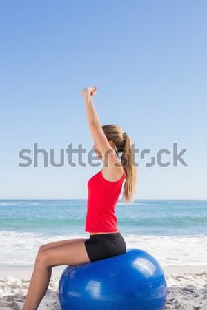 Young woman with eyes closed exercising on mat at beach Stock photo © wavebreak_media