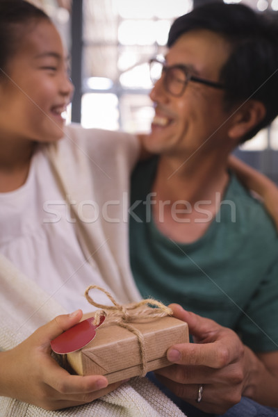 Daughter giving gift box to father in living room Stock photo © wavebreak_media