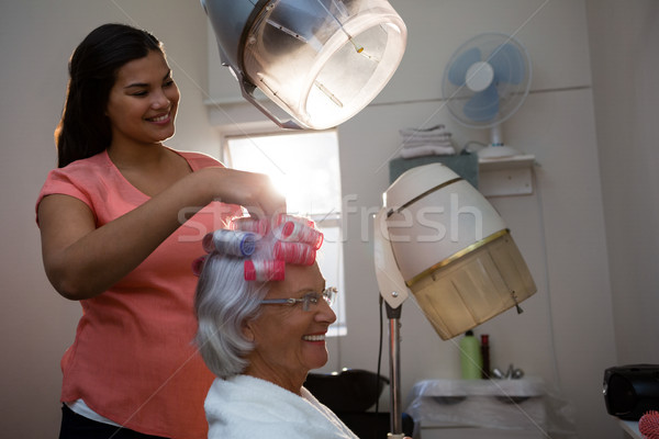 Smiling beautician removing curlers from senior woman hair Stock photo © wavebreak_media