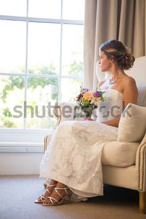 Gyönyörű menyasszony néz virágcsokor ül szék Stock fotó © wavebreak_media