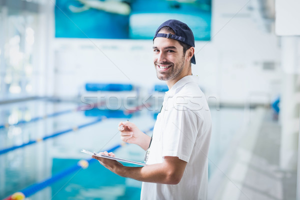 Souriant entraîneur presse-papiers piscine eau [[stock_photo]] © wavebreak_media