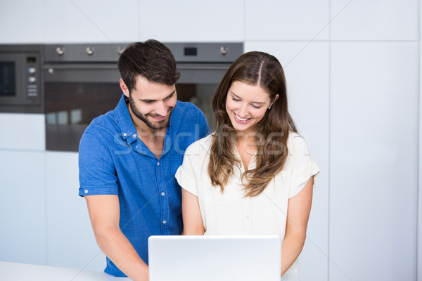 Feliz Pareja usando la computadora portátil cocina casa tecnología Foto stock © wavebreak_media