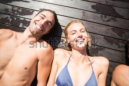  Woman smiling while husband lying on bed in background Stock photo © wavebreak_media