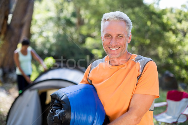 Man smiling and holding a sleeping bag  Stock photo © wavebreak_media