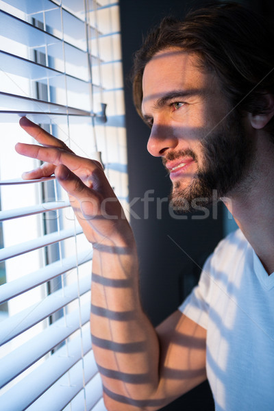 Man looking through window blinds after waking up Stock photo © wavebreak_media