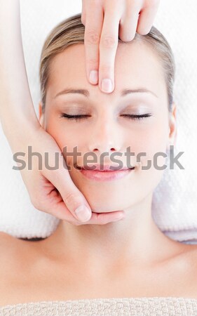 Stock photo: Portrait of a charming young woman receiving a head massage in a spa center