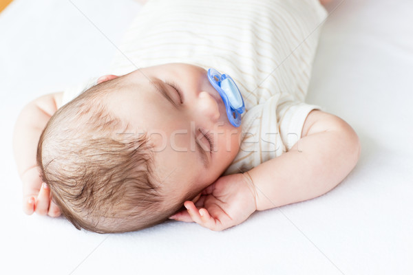Portrait of an adorable baby with a pacifier sleeping in a bed at home Stock photo © wavebreak_media