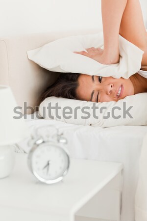 Portrait of a tired woman switching off her alarm clock in her bedroom Stock photo © wavebreak_media