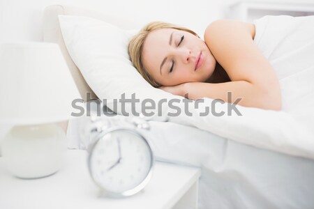 Woman awaken by an alarmclock in her bedroom Stock photo © wavebreak_media