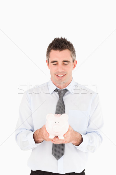 Businessman showing a piggy bank against a white background Stock photo © wavebreak_media