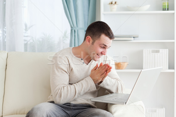 [[stock_photo]]: Heureux · homme · portable · salon · mains · internet