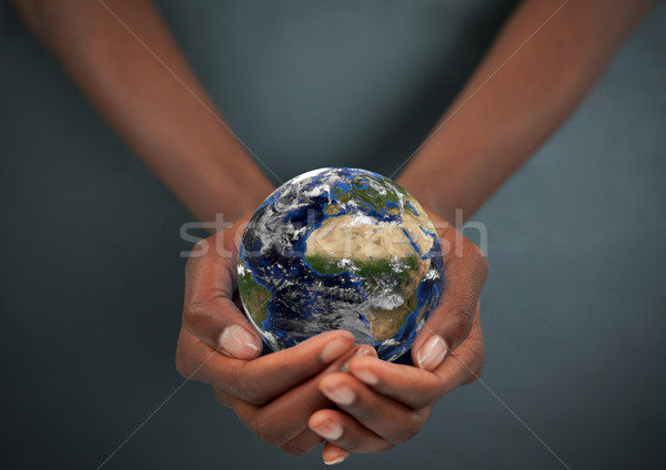 Feminine hands holding the Earth against a dark background Stock photo © wavebreak_media