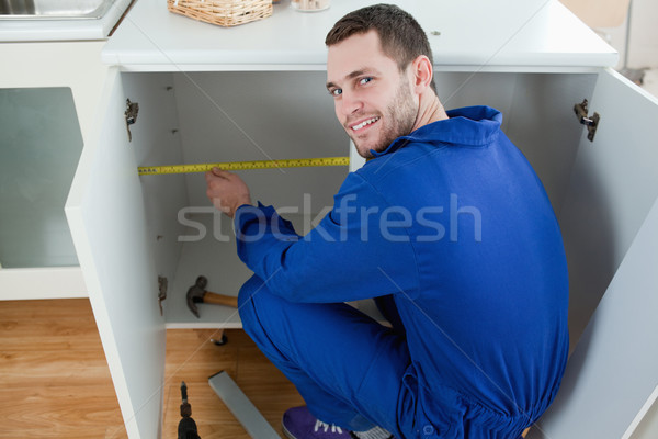 Smiling repair man measuring something in a kitchen Stock photo © wavebreak_media