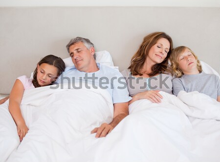 Adorable family snoozing in the bed together Stock photo © wavebreak_media