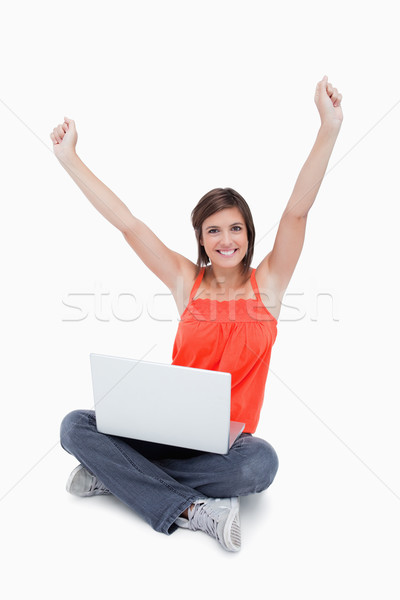 Attractive teenage sitting cross-legged and raised arms with a laptop Stock photo © wavebreak_media
