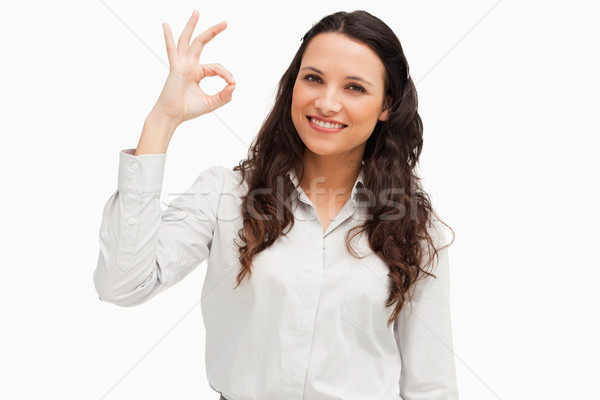Portrait of a brunette approving with hand against white background  Stock photo © wavebreak_media