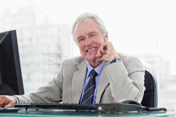 Smiling senior manager working with a monitor in his office Stock photo © wavebreak_media