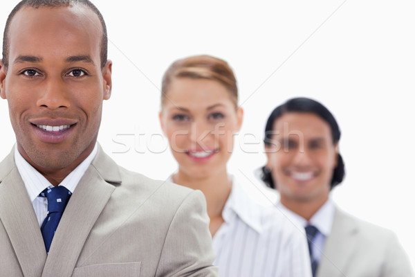 Stock photo: Big close-up of workmates in a single line smiling with focus on the first man