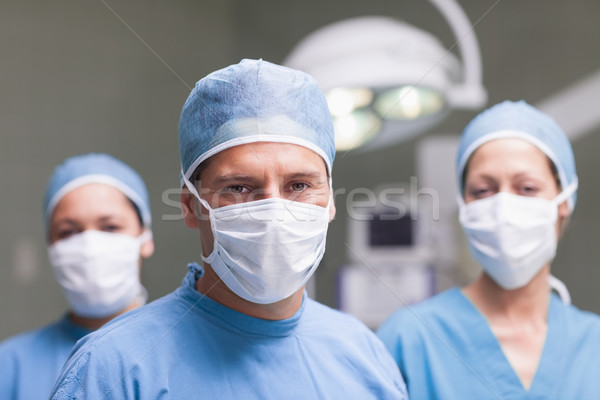 Medical team looking at camera in operating theater Stock photo © wavebreak_media
